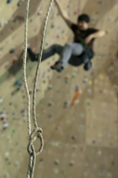 Touw loop en man op klimmen op indoor praktijk muur — Stockfoto