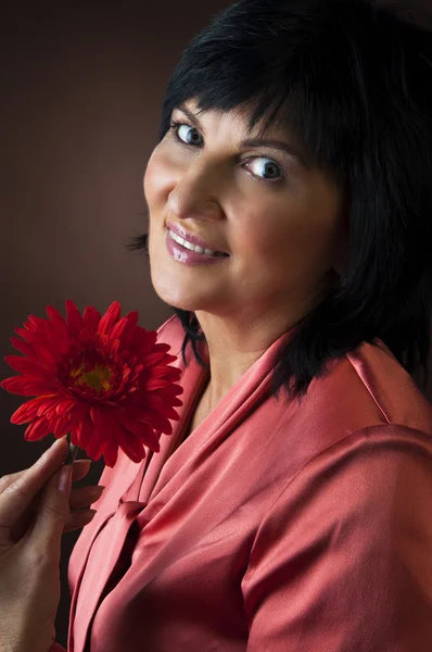 Mujer madura con flor —  Fotos de Stock