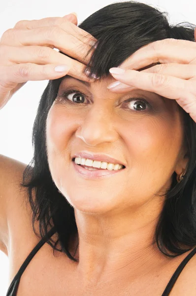Mature woman massaging her forehead — Stock Photo, Image