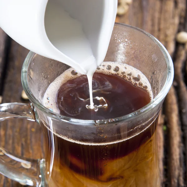 Coffee cup and a pouring milk — Stock Photo, Image