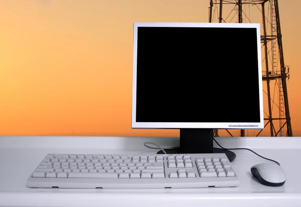 PC met avondrood en elektrische pylonen achtergrond — Stockfoto