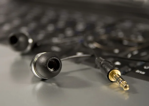 Modern Headphones on a laptop keyboard — Stock Photo, Image