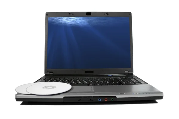 Weiße CD auf einem Laptop isoliert. schöne Lichtstrahlen auf dem Desktop. — Stockfoto