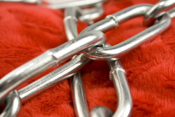 Steel chain on red fabric — Stock Photo, Image