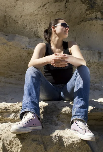 Model sitting on the rocks. Urban style — Stock Photo, Image