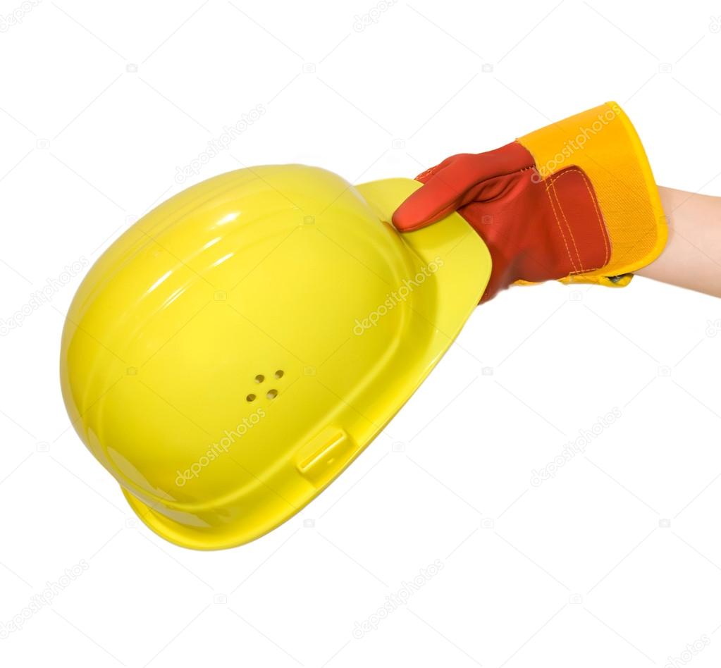 Hand in glove holding a yellow hard hat isolated