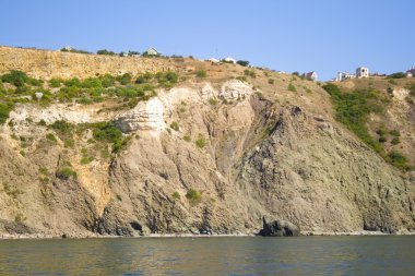 Kayalık bir kıyı şeridinde dağ. Deniz manzaralı..