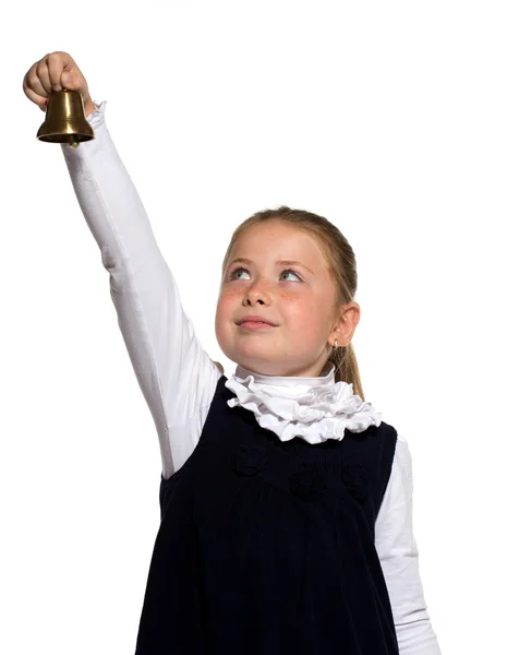 Jovem menina da escola tocando um sino dourado no fundo branco — Fotografia de Stock