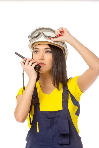 Serious female construction worker talking with a walkie talkie — Stock Photo, Image