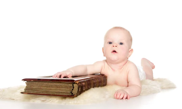 Baby thumbing big book sitting on the floor — Stock Photo, Image