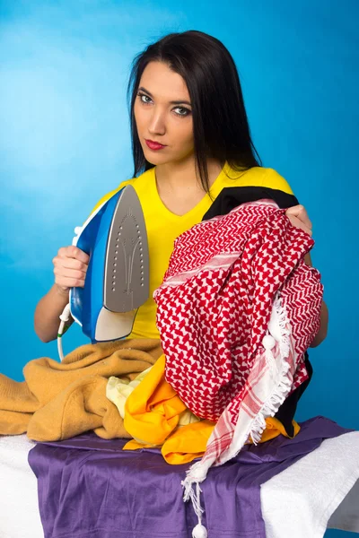Kobieta z stos ubrań prasowanie — Zdjęcie stockowe