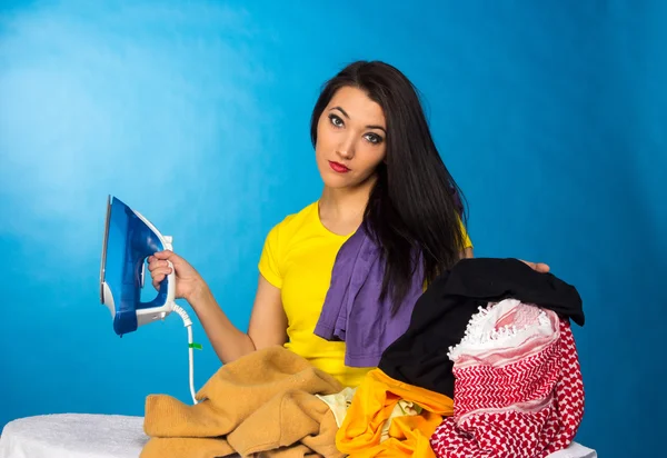 Hausarbeit, Frau mit Kleiderstapel zum Bügeln — Stockfoto