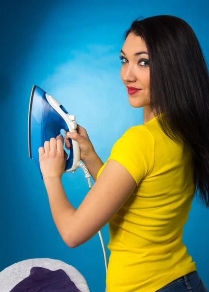 Houseworks, vrouw met stapel van kleren voor strijken — Stockfoto