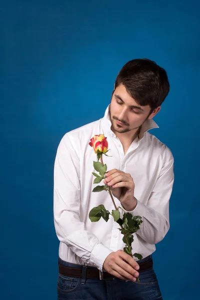 Молодой человек ищет красную розу — стоковое фото