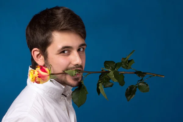 Young man holding a red rose in his mouth — Stock Photo, Image