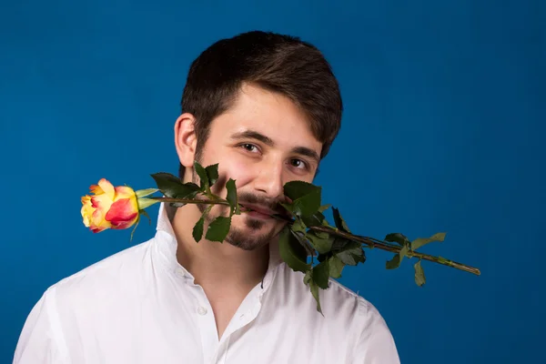 Joven sosteniendo una rosa roja en su boca —  Fotos de Stock