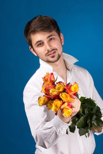Молодой человек, дающий красную розу — стоковое фото