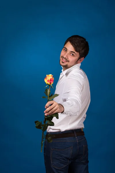 Jeune homme donnant une rose rouge — Photo