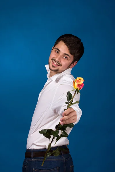 Молодой человек, дающий красную розу — стоковое фото