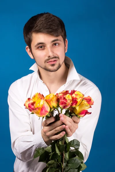 Muž s kyticí rudých růží — Stock fotografie