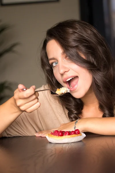 Jovem mulher comendo o bolo de amora — Fotografia de Stock