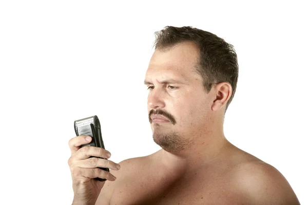 Мужчина бреет лицо электрической бритвой — стоковое фото