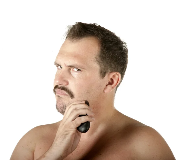 Чоловік голиться обличчя з електричною бритвою — стокове фото