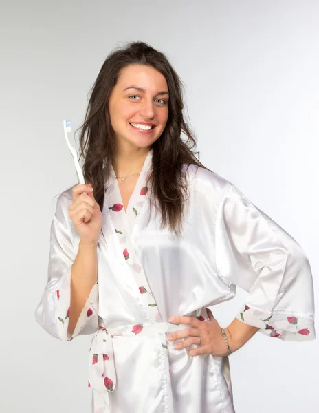Mujer en peignoir con cepillo de dientes —  Fotos de Stock