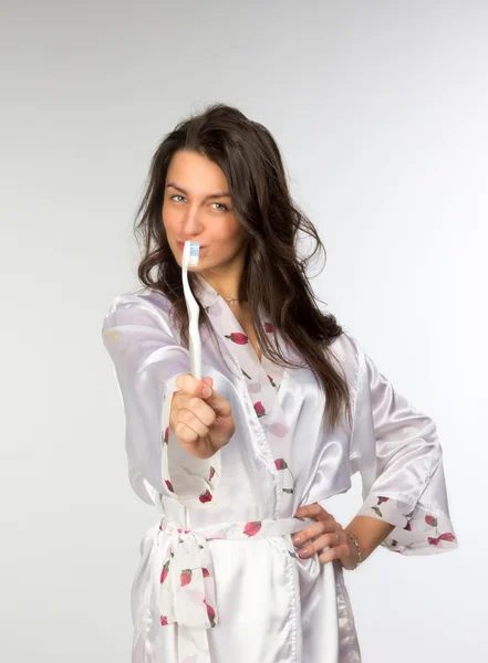 Kvinna i peignoir med tandborste — Stockfoto