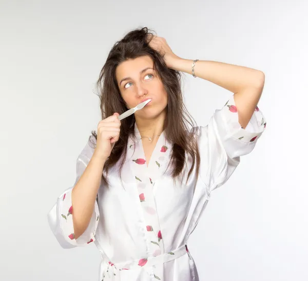 Женщина в пеньюаре с зубной щеткой — стоковое фото