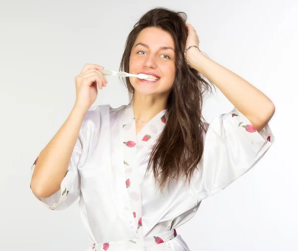 Mulher em peignoir com escova de dentes — Fotografia de Stock