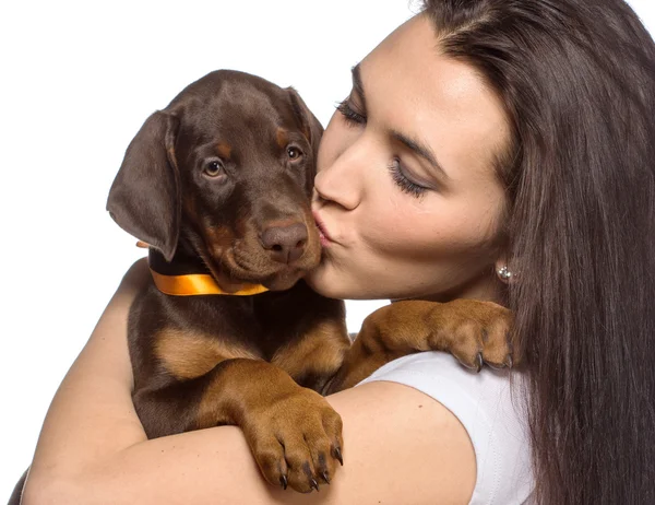 Brunette meisje kuste haar puppy geïsoleerd op witte achtergrond Stockfoto