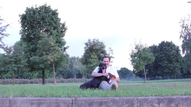 Чоловік грає з собакою — стокове відео