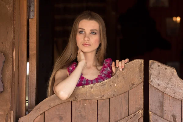 Docela dlouhé vlasy cowgirl stojící v saloonu vchodu — Stock fotografie