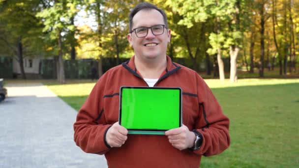 Man som håller Tablet dator med grön skärm och kromnyckel. — Stockvideo
