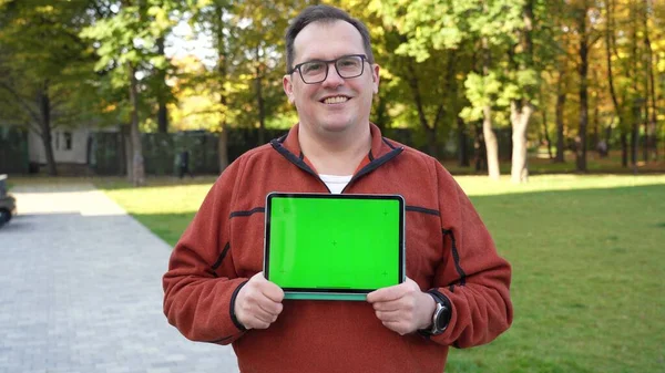 Hombre sosteniendo Tablet ordenador con pantalla verde y croma clave. — Foto de Stock