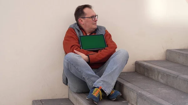 Kirúgott kaukázusi férfi munkás ül a lépcsőn depresszióban zöld képernyő tabletta számítógép. — Stock Fotó