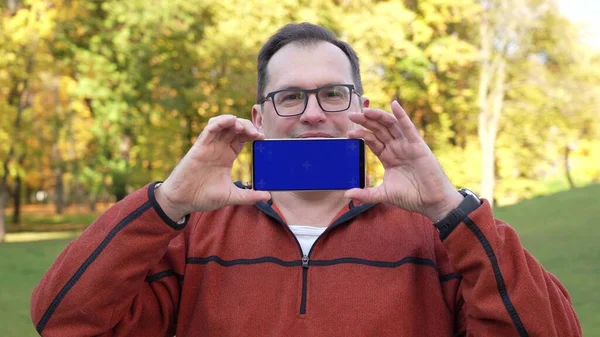 Man holding smartphone con pantalla azul y croma key. — Foto de Stock