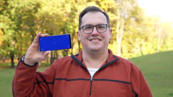 Чоловік тримає смартфон з синім екраном і ключем хроми . — стокове відео