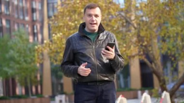 Milenyum erkeği elinde telefonla romantik bir buluşma ayarlıyor.