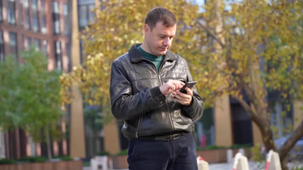 Man in een zwart jasje ontvangt een bericht dat zijn weddenschap heeft gewonnen — Stockvideo