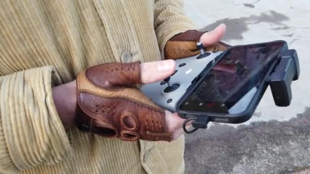 Zdalne sterowanie quadcopterem konsumenckim w męskich dłoniach w rękawiczkach bez palców — Wideo stockowe
