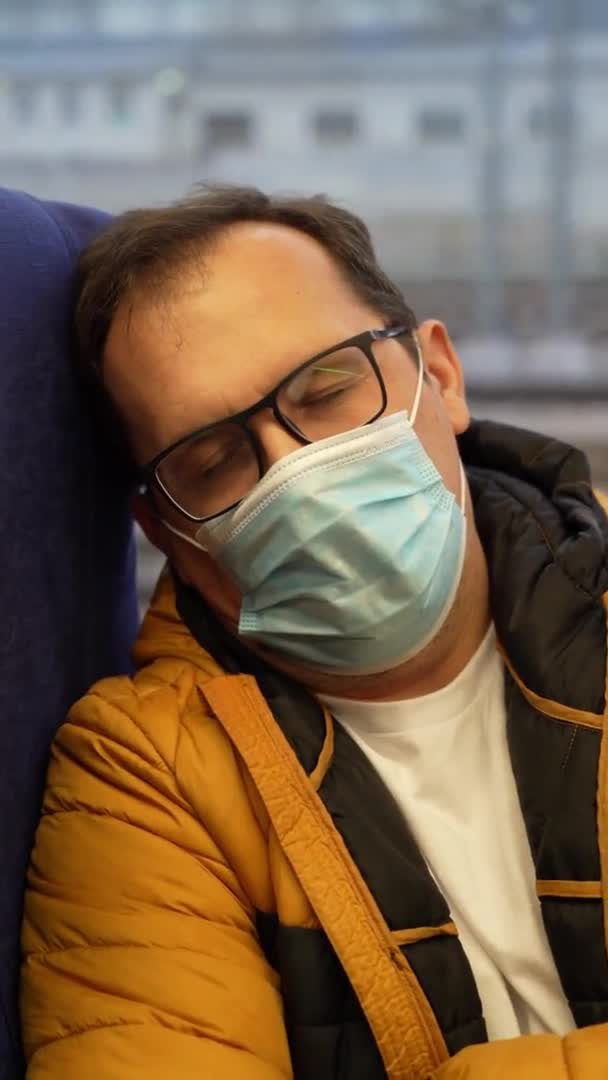Vermoeide man met een medisch masker rijdt in de voorstedelijke trein — Stockvideo