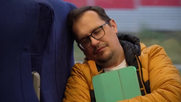 Zmęczony człowiek jeździ pociągiem podmiejskim — Wideo stockowe