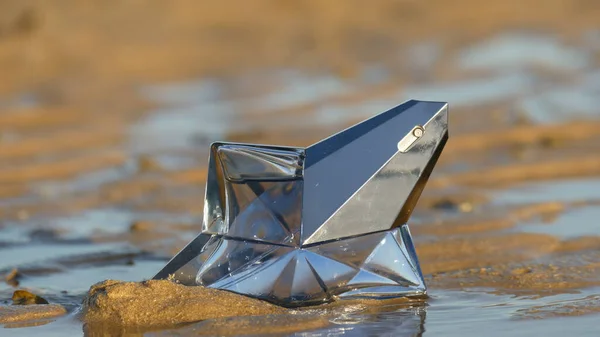 Lost Star Perfume bottle on on the shore at low tide