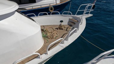 Diğer ikisi arasında demirlemiş bir teknenin pruvasındaki ipler.