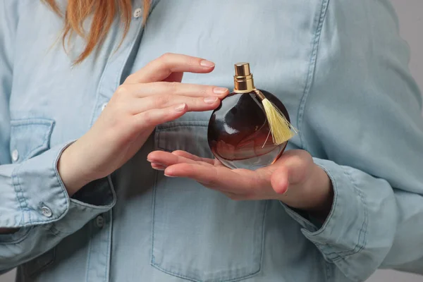 Butelka Perfum Rękach Kobiety Noszącej Niebieskie Dżinsy — Zdjęcie stockowe