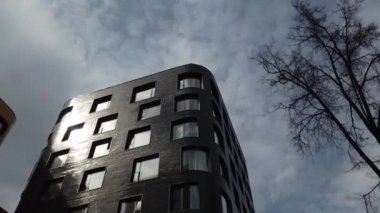 Yüksek katlı bir apartmanın dış cephesi, pencereleri ve balkonları.