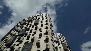 Yüksek katlı bir apartmanın dış cephesi, pencereleri ve balkonları.