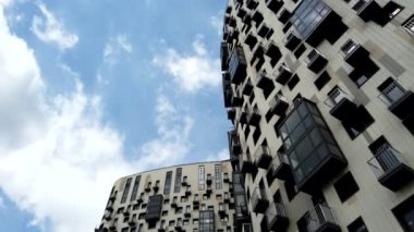 Yüksek katlı bir apartmanın dış cephesi, pencereleri ve balkonları.